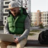 Man werkt buiten met bodywarmer en laptop