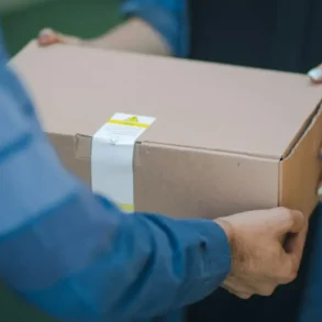 Man geeft kartonnen doos aan vrouw