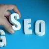 Hand takes letter s of SEO and letter G