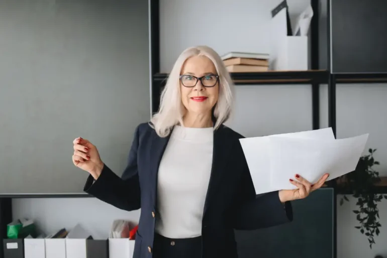 vrouw met bril houdt documenten in de hand
