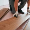 man is bezig om pvc vloer te leggen