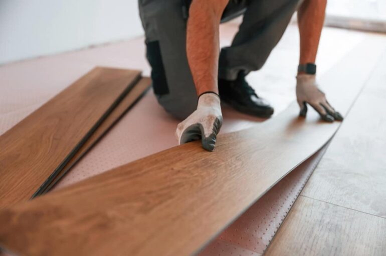 man is bezig om pvc vloer te leggen