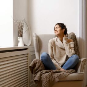 vrouw zit voor radiator ombouw
