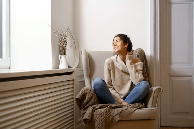 vrouw zit voor radiator ombouw