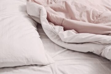 Roze dekbed en wit hoofdkussen op bed