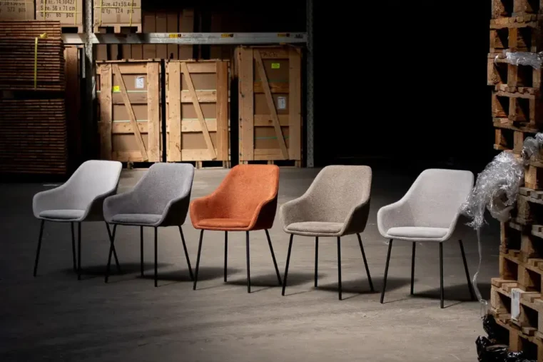 Vijf gestoffeerde stoelen in verschillende kleuren in magazijn.