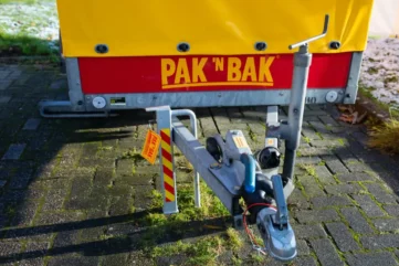 Ongesloten aanhanger op parkeerplaats met PAK 'N BAK logo.