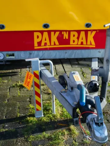 Ongesloten aanhanger op parkeerplaats met PAK 'N BAK logo.