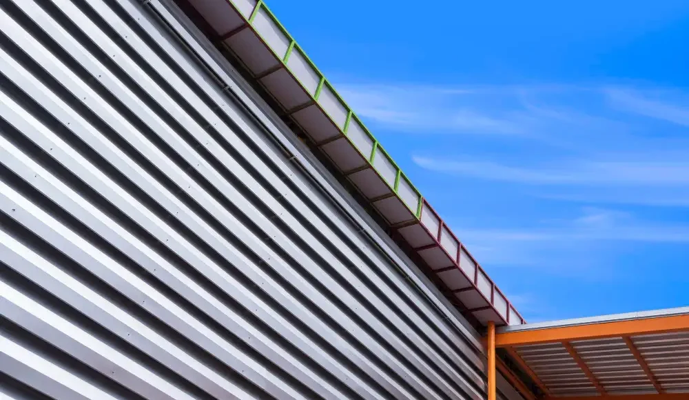 Moderne gevel van sandwichpanelen en dak met blauwe lucht