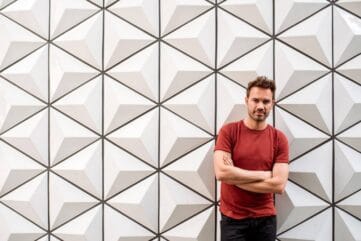 Man in rode trui tegen akoestische wand