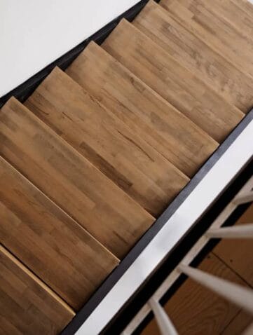 Bovenaanzicht van houten trap met witte leuning