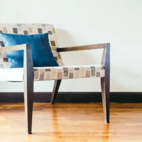 Stijlvolle stoel met kussen op houten vloer