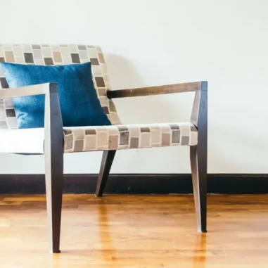 Stijlvolle stoel met kussen op houten vloer