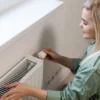 Vrouw stelt radiator in woonkamer af.