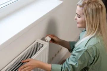 Vrouw stelt radiator in woonkamer af.