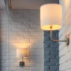 Wandlamp verlicht witte bakstenen muur.
