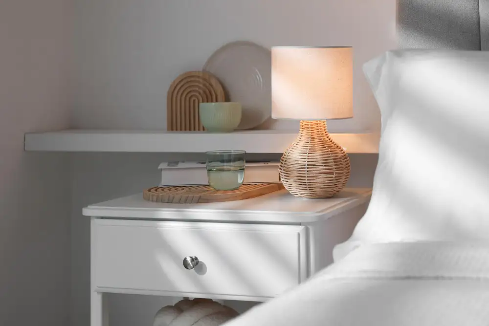Nachtkastje met rotan lamp en glas water