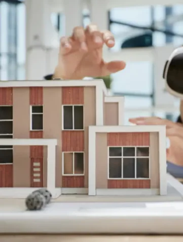 Man met VR-bril bij schaalmodel van huis