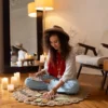 jonge vrouw zit op de grond op een kleed en leest tarot kaarten.