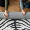 twee mensen rollen vloerkleed op