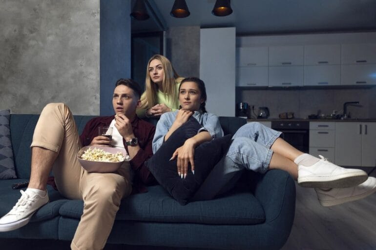 jonge mensen kijken spannende film met popcorn