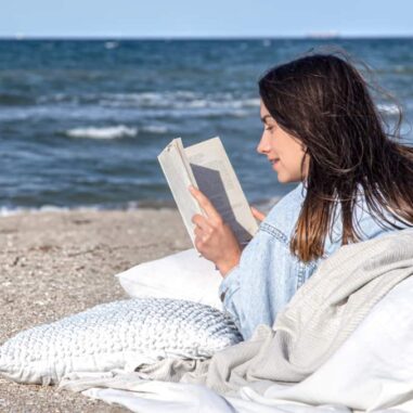 vrouw leest boek op het strand