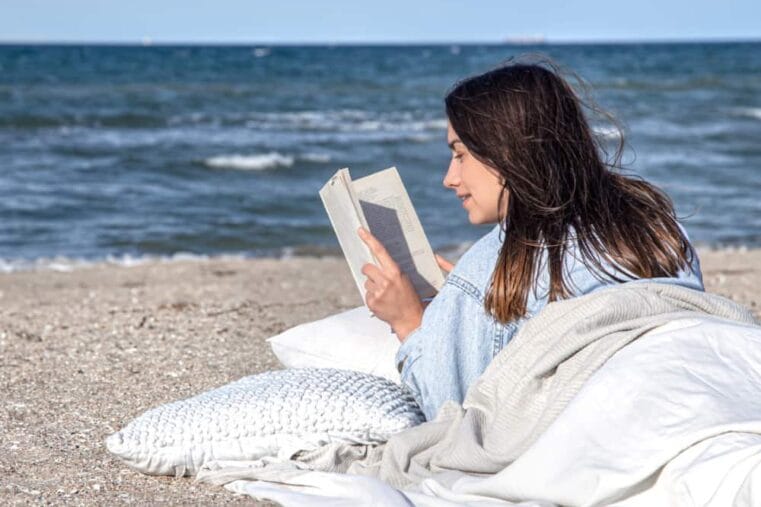 vrouw leest boek op het strand