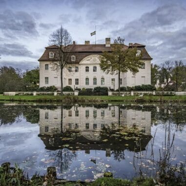 Historisch kasteel met weerspiegeling in vijver.
