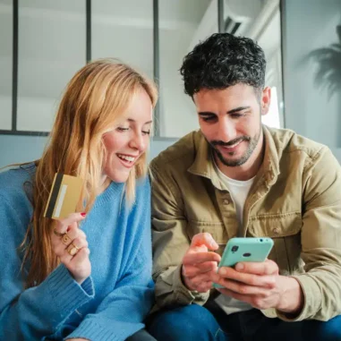vrouw met bankpas kijkt samen met man op mobiele telefoon