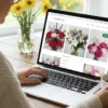 Vrouw bekijkt bloemenwinkel website op laptop.
