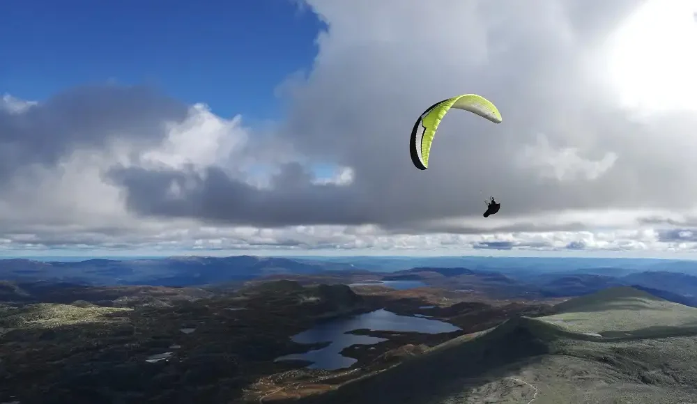 Parapente boven kust met meren en wolken