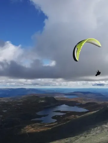 Parapente boven kust met meren en wolken