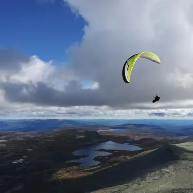 Parapente boven kust met meren en wolken