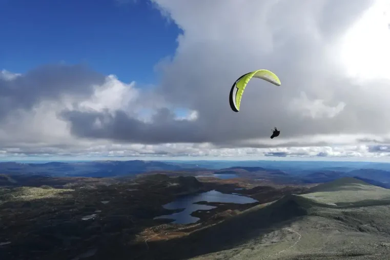 Parapente boven kust met meren en wolken