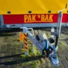 Ongesloten aanhanger op parkeerplaats met PAK 'N BAK logo.