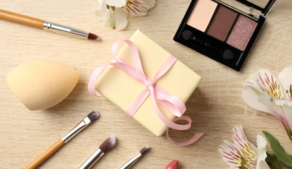 Cadeau met make-up en bloemen op tafel